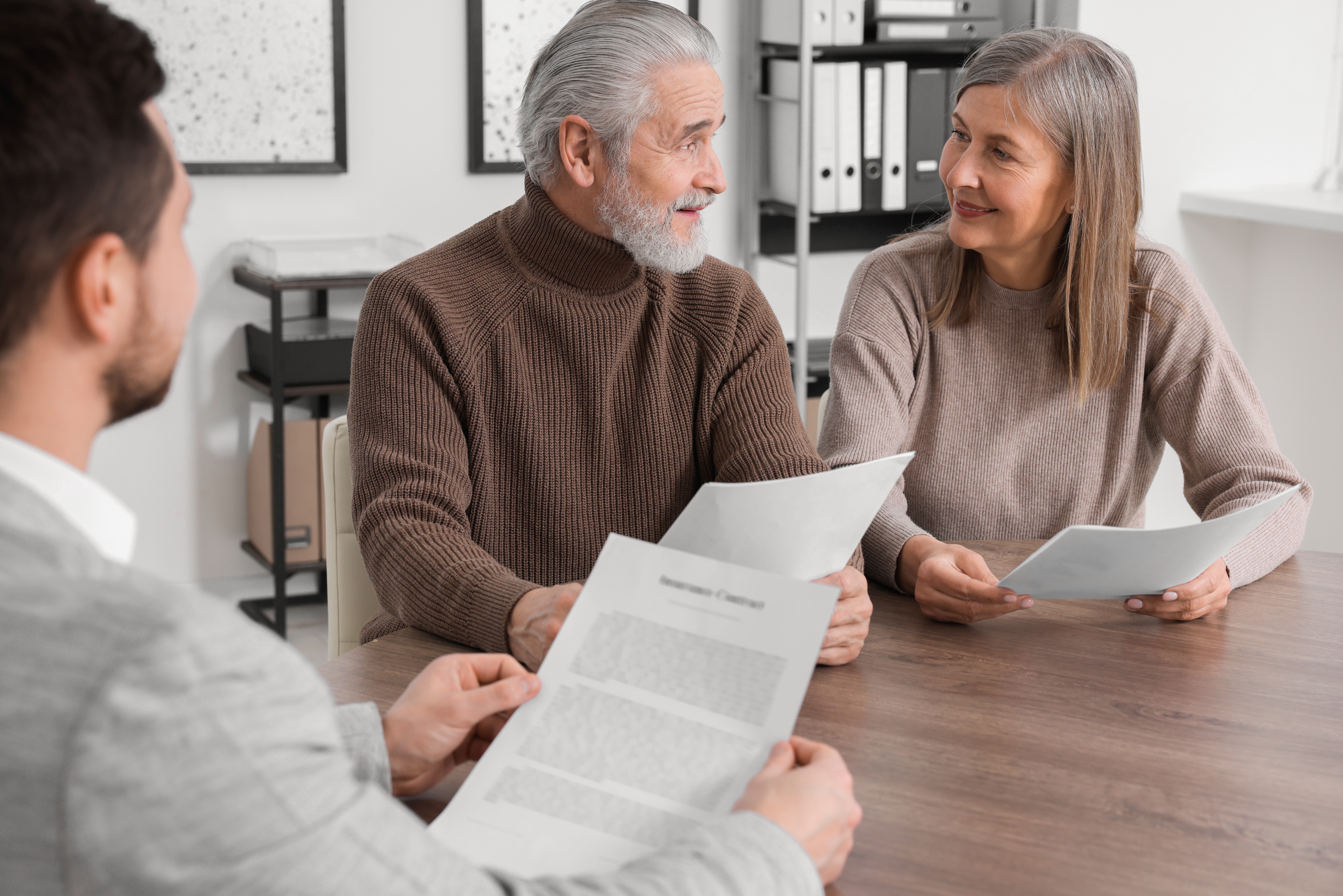 Retired couple reviewing Social Security benefits, pension income, and federal tax documents with a tax professional