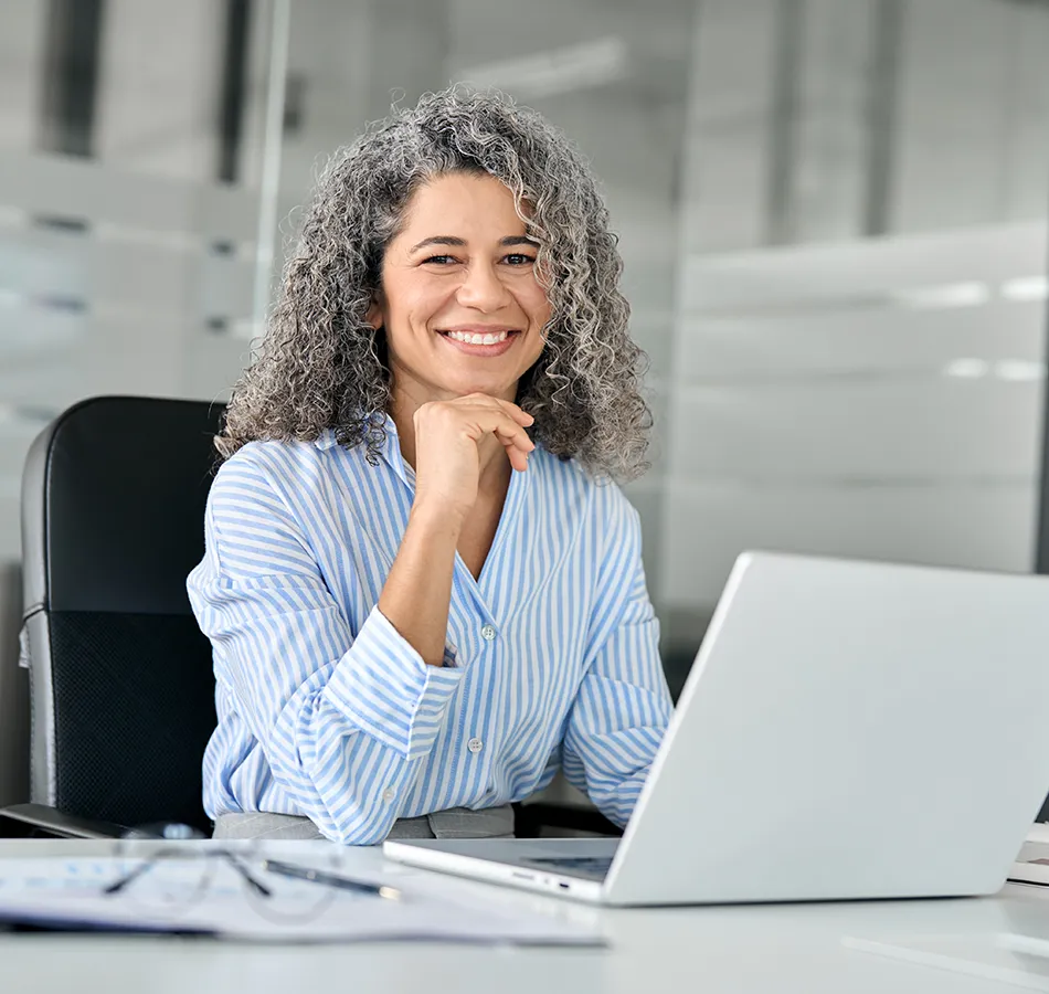 A woman tax-planning expert working in an office with glass walls.