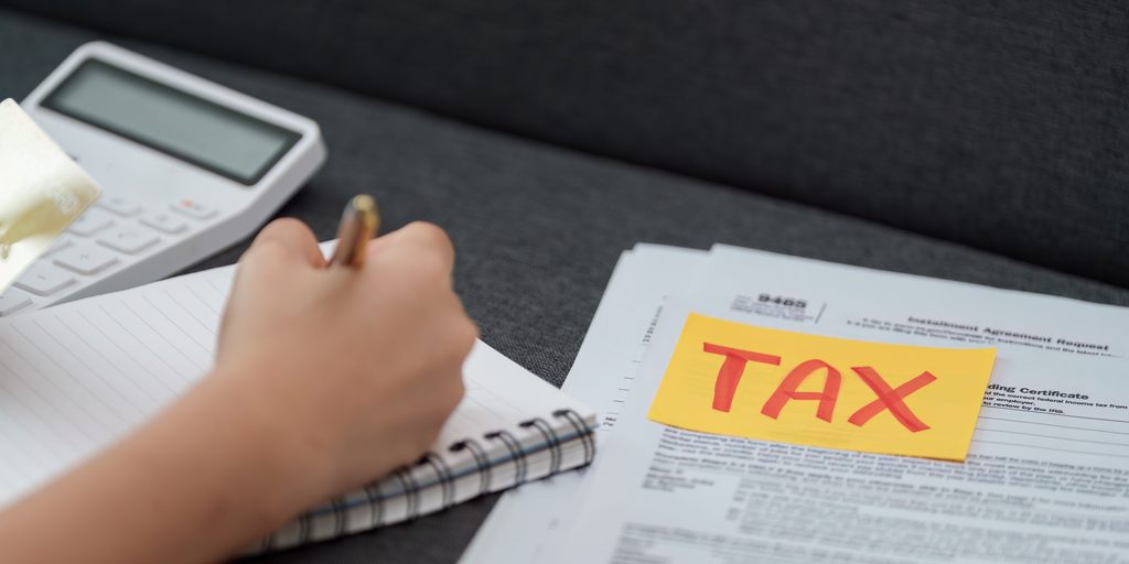 Taxpayer organizing tax returns, W-2s, receipts, property records, and financial documents by year for IRS record retention.