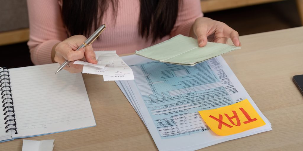 Taxpayer organizing charitable donation receipts, nonprofit contribution records, and noncash donation documents for 2026 taxes