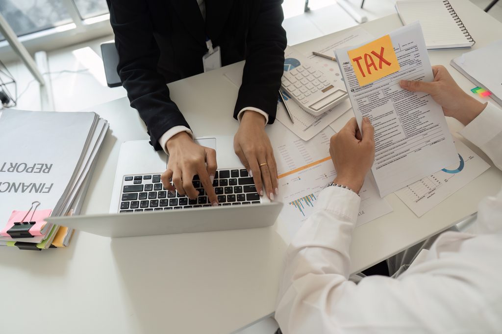 Taxpayer reviewing several years of unfiled tax returns and IRS notices with a tax professional.
